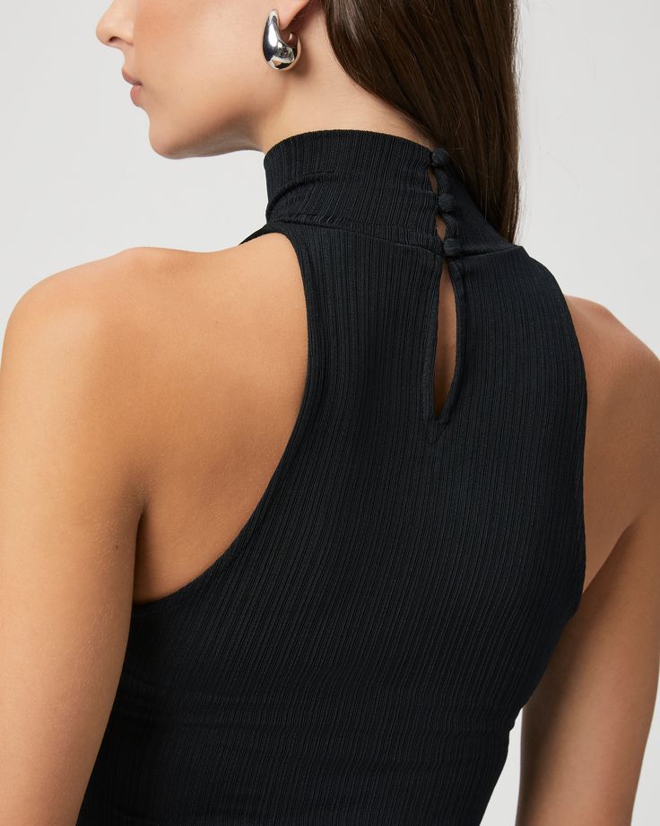 Crafted from a nylon blend with an elevated feel, this chic black tank top is designed with a pleated effect and a halter mock neck silhouette. The Momo Tank is the perfect layering piece to add to your year-round wardrobe. | Momo Tank Top - Black | Size Large Chic Black High Neck Halter Top, Chic Ribbed Sleeveless Halter Top, Black High Neck Tank Top For Night Out, Elegant Black High Neck Halter Top, Chic High Stretch Sleeveless Halter Top, Chic High Stretch Halter Top, Chic Sleeveless High Stretch Halter Top, Black Ribbed Halter Neck Tank Top, Black High Neck Halter Top For Night Out