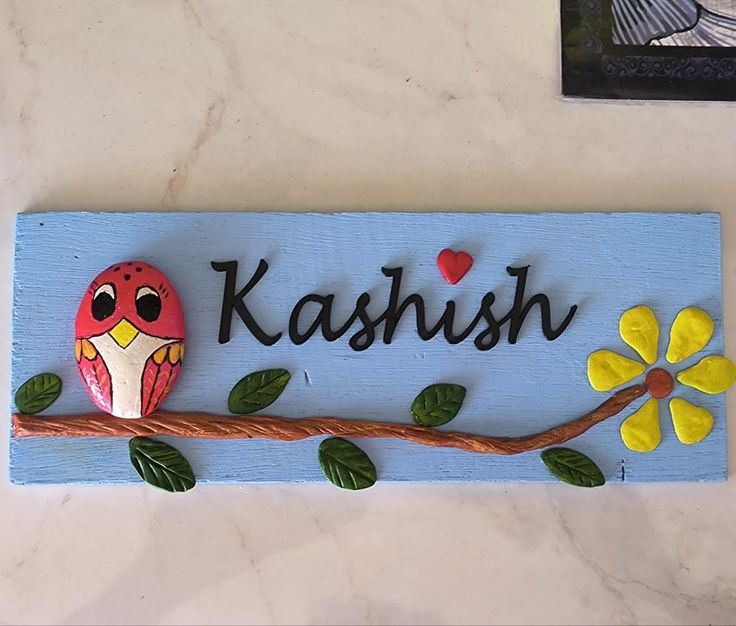 a wooden sign that says kashih with an owl sitting on a branch