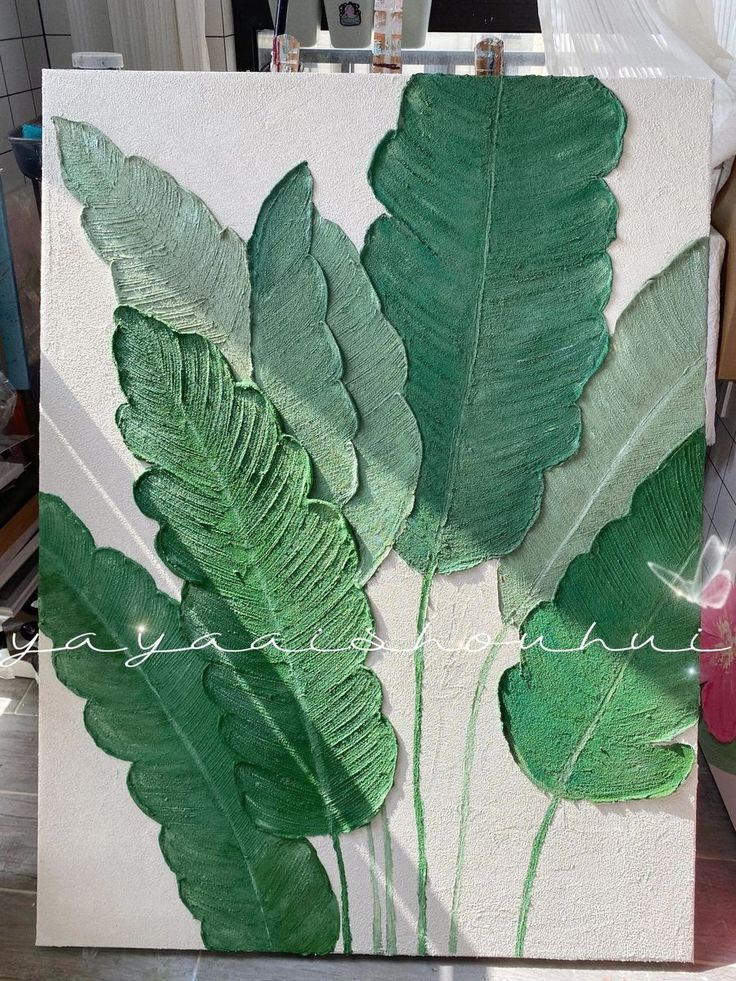 a painting with green leaves painted on it