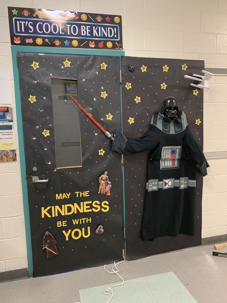 darth vader costume on display in front of a star wars bulletin board that says it's cool to be kind