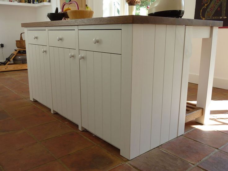 a kitchen with white cabinets and an island in the middle of the flooring area