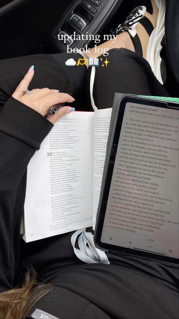 a woman is reading a book while sitting in her car