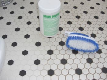 a white and blue brush sitting on top of a bathroom floor