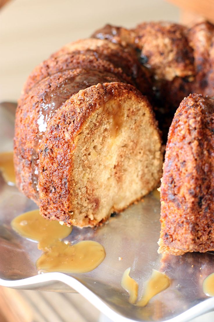 a bundt cake is cut in half and sitting on a plate with caramel sauce