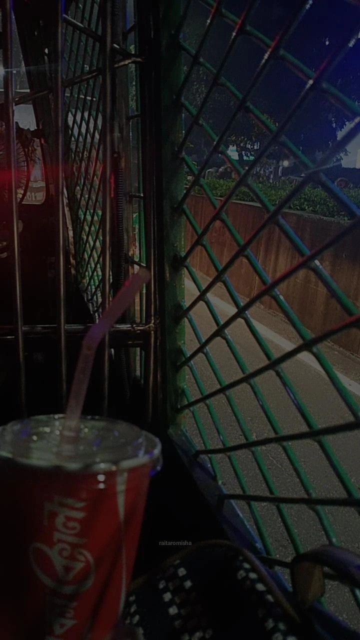 a soda drink in a plastic cup with a straw sticking out of it's side