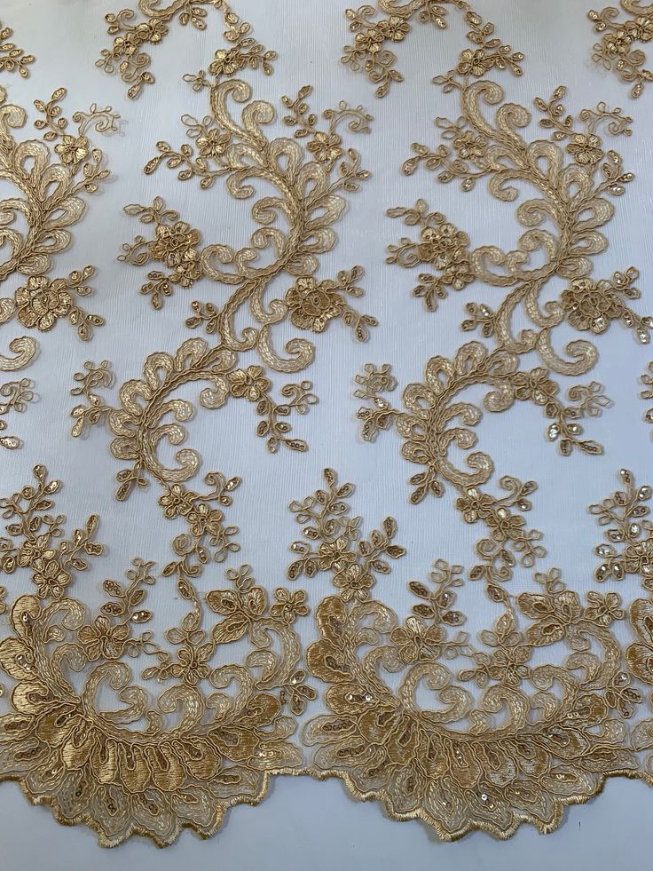 Melody GOLD Polyester Floral Embroidery with Sequins on Mesh Lace Fabric by the Yard for Gown, Wedding, Bridesmaid, Prom - 10002 Stand out magnificently as you gracefully appear wearing this stunning flowing fabric. Intricate embroidery adorns this fabric, with some sequins scattered all throughout, giving it a lavish and regal feel. Content: 100% polyester Stretch: Minimal to none Width: 50 to 52 inches Edge: Scalloped on both edges Uses: Wedding dress, evening gown, formal wear, tops, skirts, Lace Vail, Gold Lace Gown, Gold Lace Fabric, Embroidery With Sequins, Embroidery Tshirt, Embroidery Shoes, Embroidery Top, Gowns For Girls, Linens And Lace