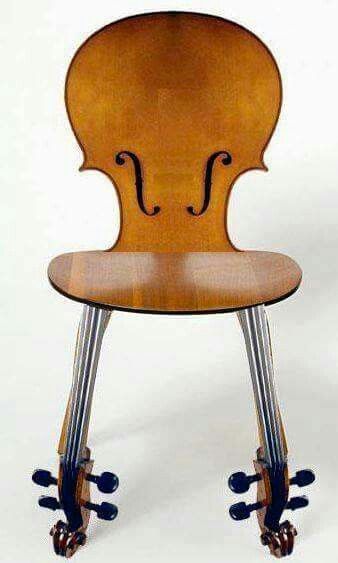 an image of a chair with a violin on it's back legs and wheels