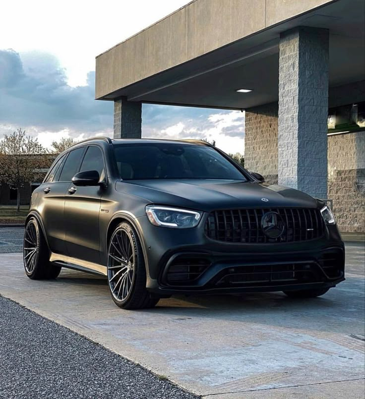 a black mercedes suv parked in front of a building