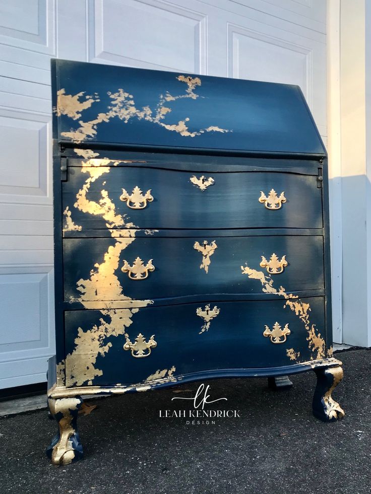 a blue and gold painted chest of drawers