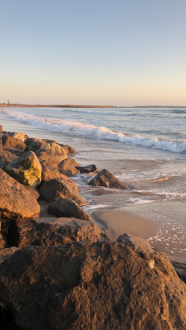 the beach is lined with rocks and water