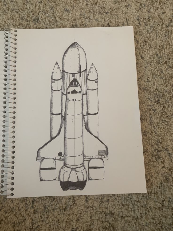 a drawing of a space shuttle on top of a spiral notebook