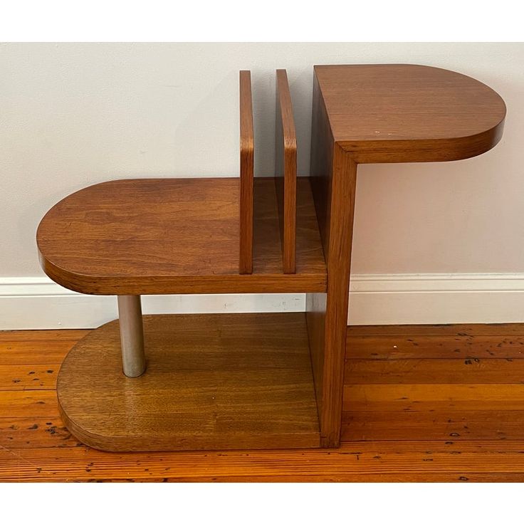 a wooden table sitting on top of a hard wood floor next to a white wall