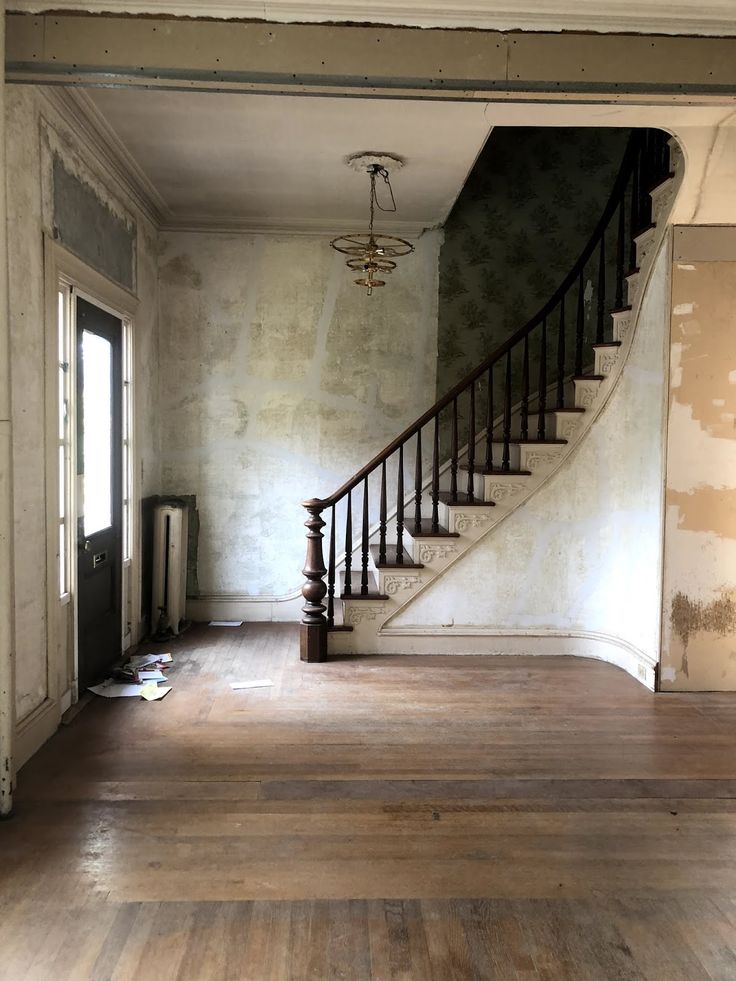 an empty living room with stairs leading up to the second floor