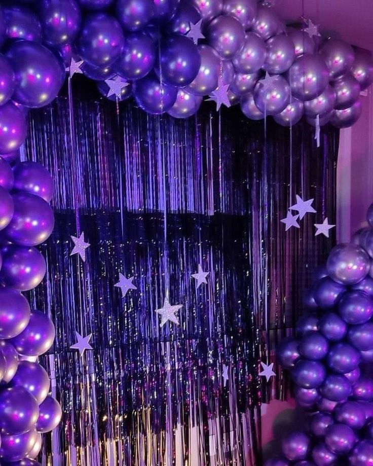 purple balloons and streamers are hanging from the ceiling