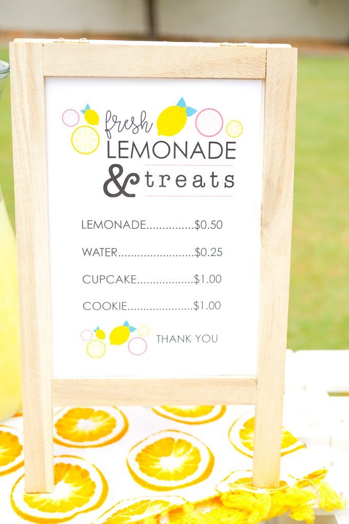 a lemonade and treats sign sitting on top of a table