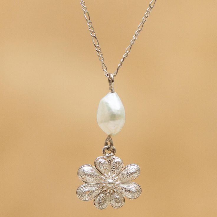 By designer Eva Souto this sterling silver necklace features a pendant crowned with a white cultured pearl. The filigree is so tightly coiled inside the petals that it seem almost solid. The challenge is to create new filigree designs without leaving behind cultural significance and tradition. My work includes a dose of nostalgia Soto confides. Delicate Silver Jewelry With Pearl Pendant, Silver Flower Jewelry With Pearl Drop, Classic Silver Necklace With Flower Shape, Elegant Engraved Flower Necklace, Silver Flower Pearl Necklace For Wedding, Classic Silver Jewelry With Flower Charm, Silver Flower Jewelry With Pearl Charm, Silver Floral Jewelry With Pearl Charm, Silver Pearl Jewelry In Flower Shape