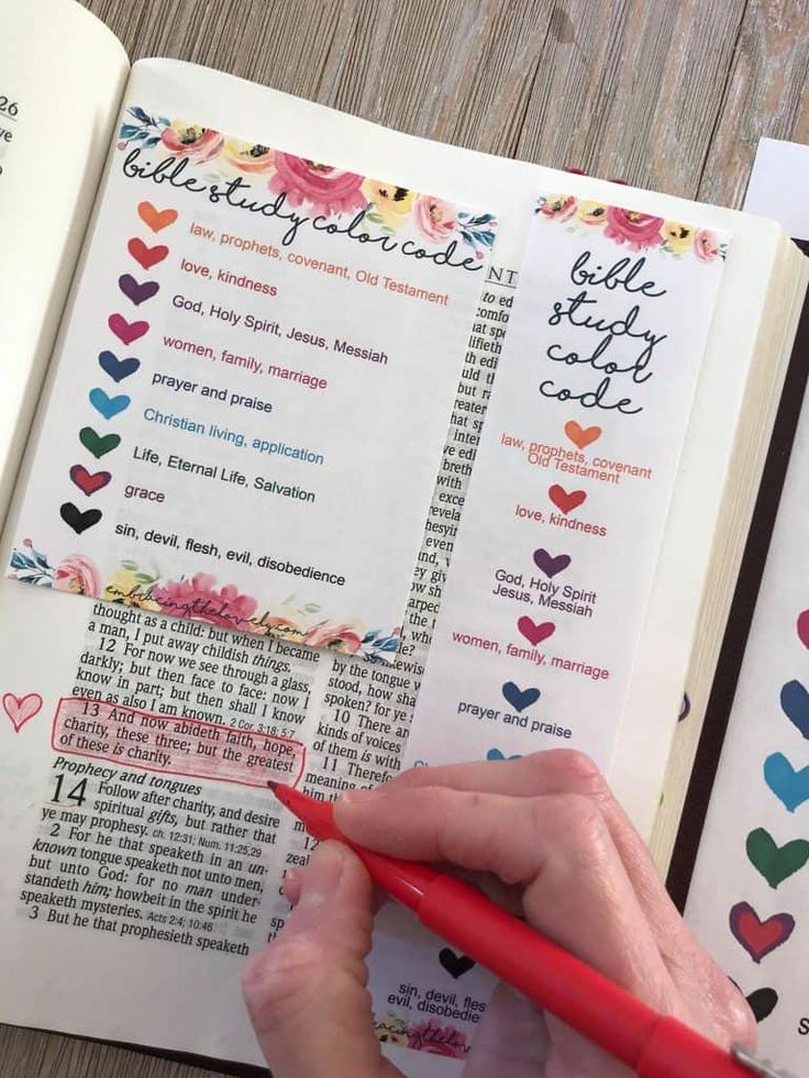 a person is writing on a book with hearts