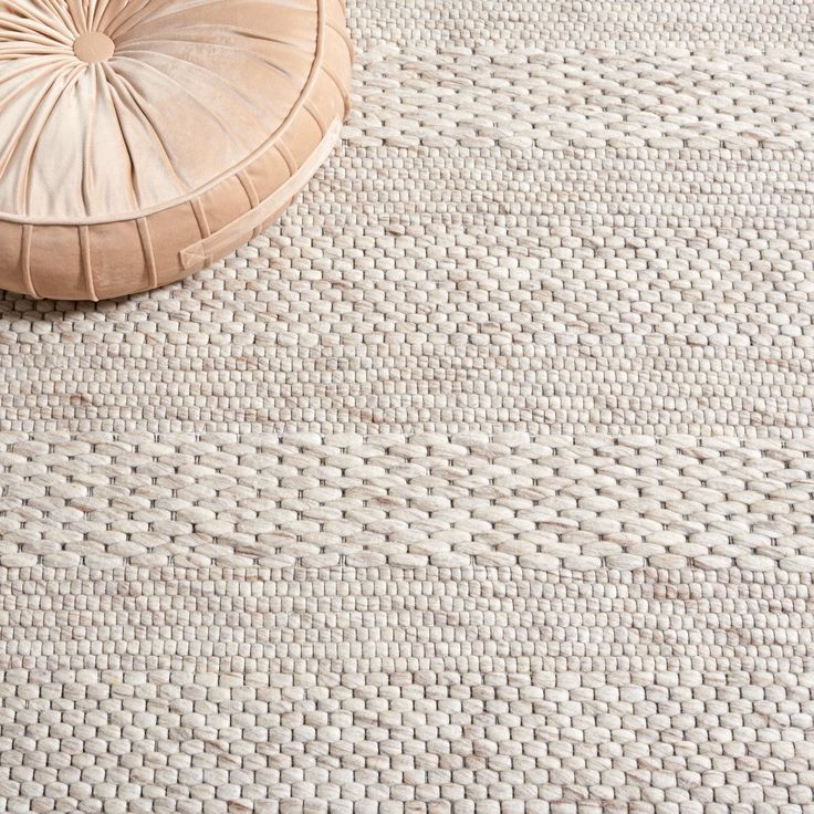 a round cushion sitting on top of a rug