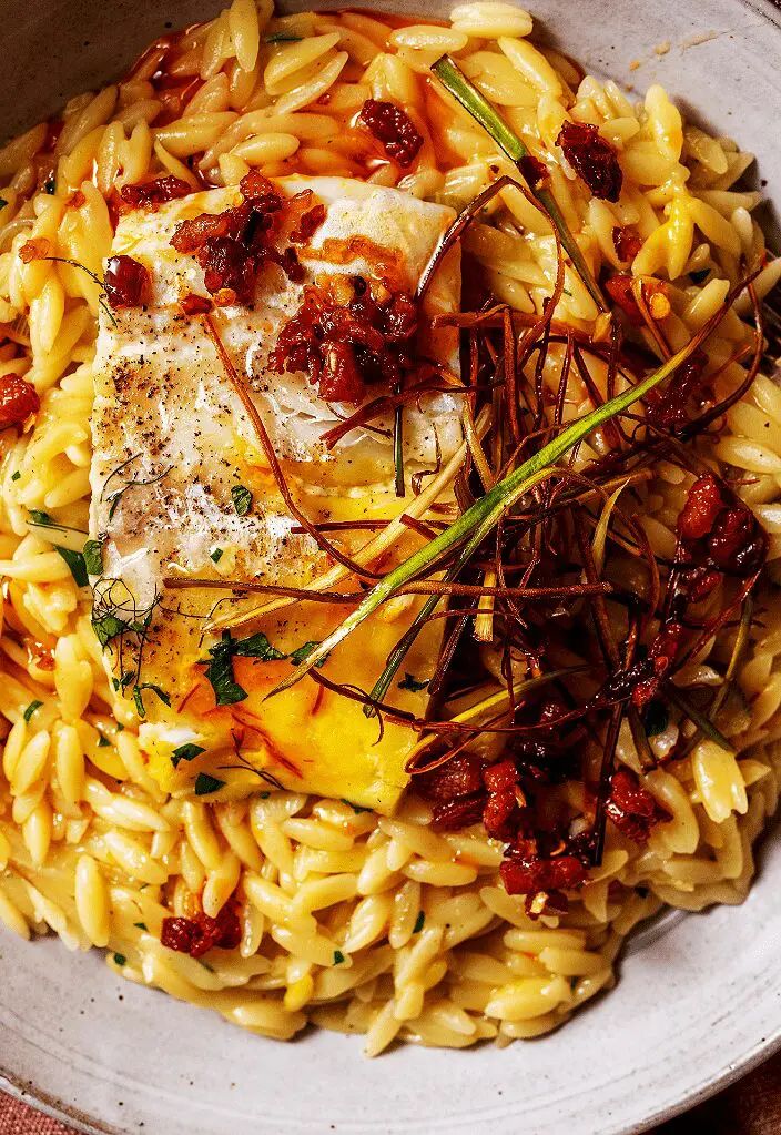 a bowl filled with pasta and meat on top of a table