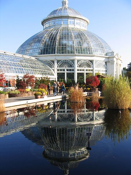 people are standing in front of a large building with a glass dome on it's roof