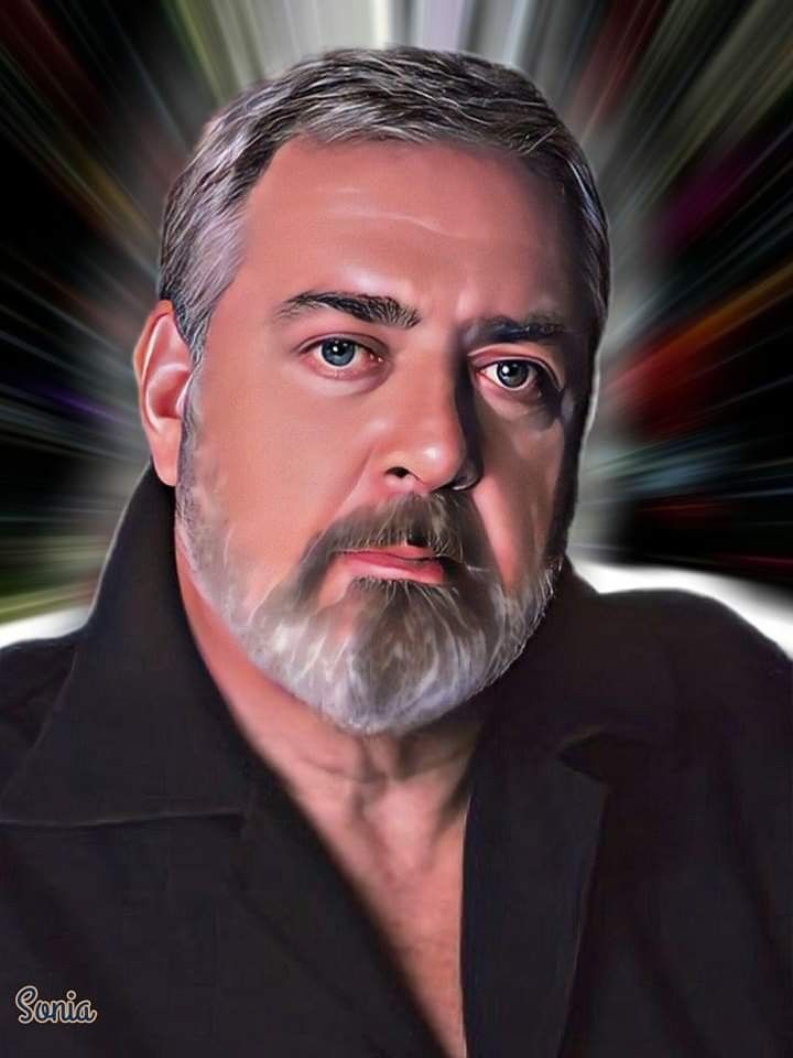 a man with grey hair and beard wearing a black shirt