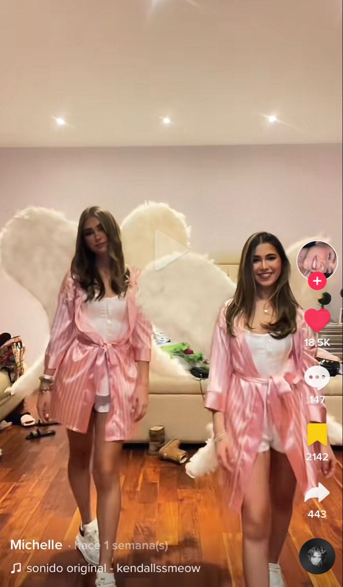 two young women dressed in pink and white posing for the camera