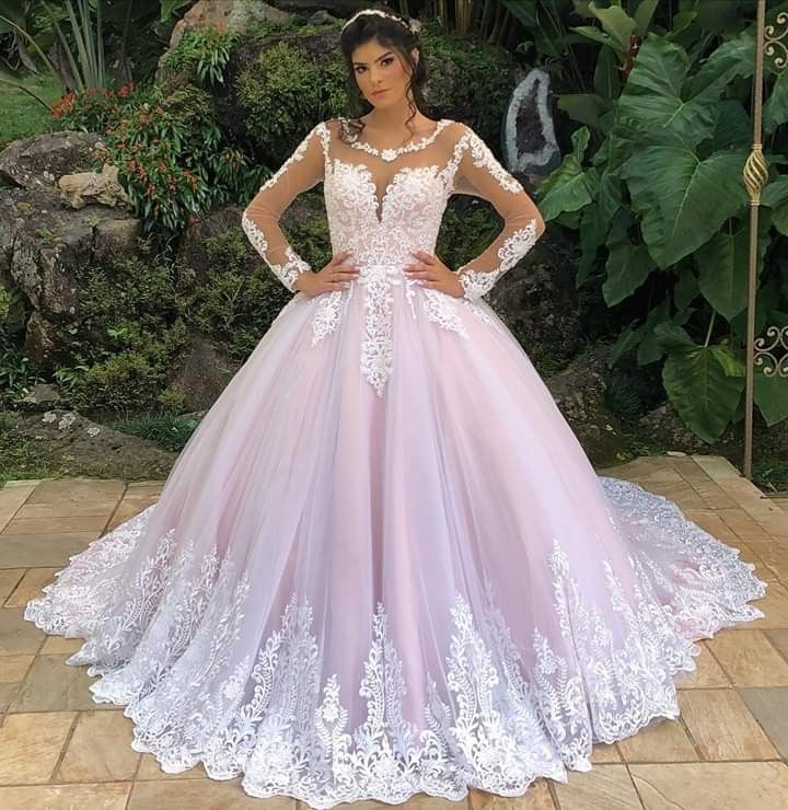 a woman in a pink and white wedding dress standing on a tile floor with her hands on her hips