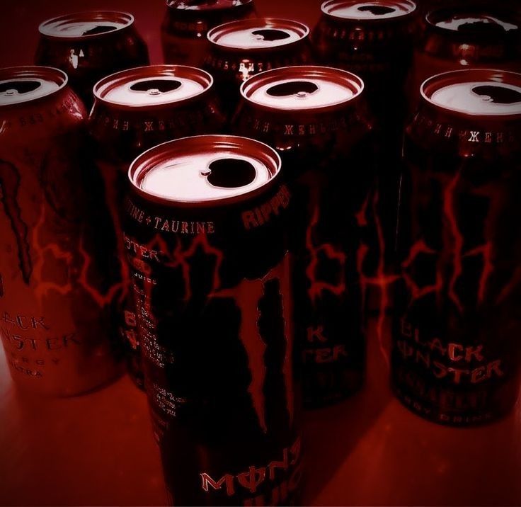 many black and red soda cans on a table