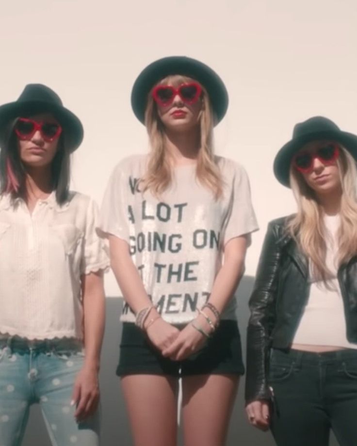 three women wearing hats and sunglasses standing next to each other