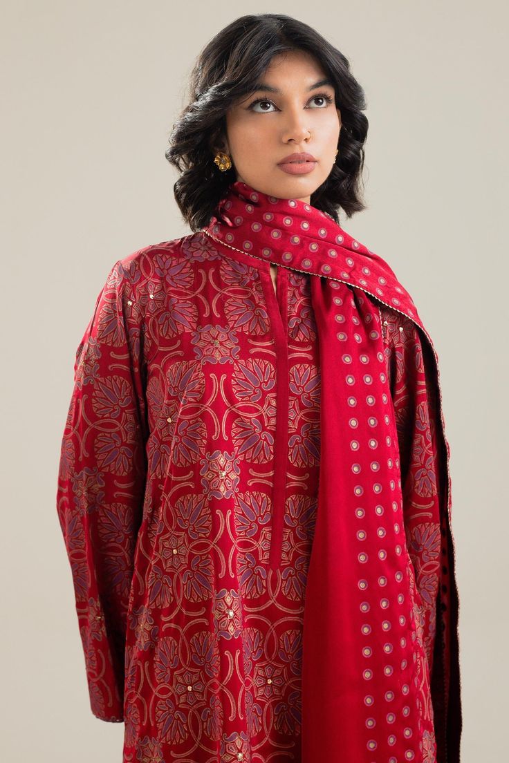 TOP:- Silk CharmeuseBOTTOM:- RawsikDUPATTA:- Silk CharmeuseOur scarlet silk shirt features a geometrical block print pattern with mukesh details. It is styled with a heavily worked mukesh lower and a dupatta with a unique polka dot border in block print. Disclaimer: Minor variations in these ensembles are intrinsic to the process of creating handcrafted products and add to their appeal. Printed Silk Kurta For Festive Occasions, Festive Silk Tops With Printed Motifs, Designer Long Sleeve Sets With Dupatta, Silk Workwear Sets With Printed Motifs, Silk Sets With Printed Motifs For Workwear, Festive Printed Silk Kurta, Designer Silk Kurta With Block Print, Straight Kurta With Printed Motifs For Work, Printed Silk Long Sleeve Kurta