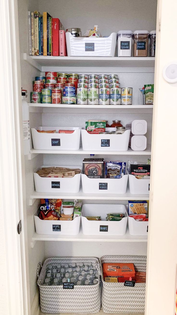 an organized pantry with white bins filled with food