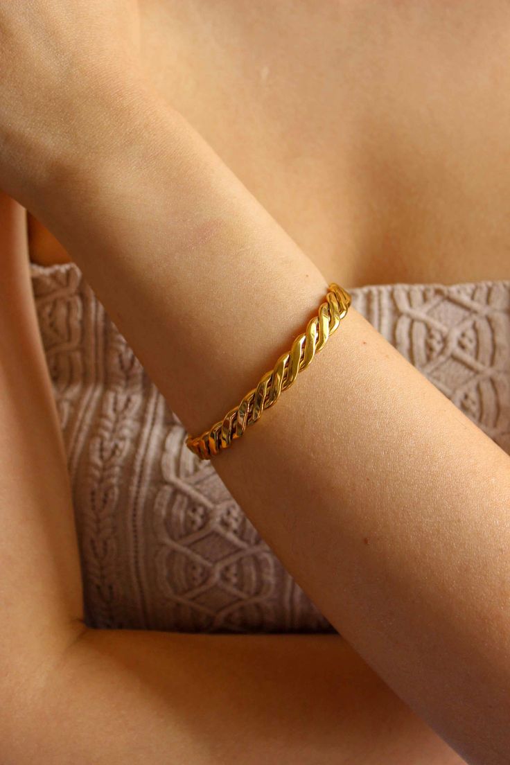 PRODUCT DESCRIPTION Introducing our Twist Bangle, a stylish and versatile accessory that adds a touch of contemporary elegance to any outfit. This bangle features a unique, twisted design that symbolizes the interconnectedness of life's moments and the beauty of twists and turns along the way. Statement Gold Bangle Water Resistant 18k Gold-plated on Titanium Steel One Size: Oval Shape that fits small wrists from 14-16cm Width: 0.7cm Read our full Jewellery Care Guide here Read our Sizing Guide h Modern Twist Bangle As Gift, Elegant Braided Bangle Bracelet, Elegant Everyday Braided Bangle Bracelet, Modern Twist Bangle Bracelet As Gift, Modern Twist Bangle Bracelet For Gift, Gift Modern Twist Twisted Bracelets, Elegant Twisted Bracelets As Gift, Modern Twist Bangle For Formal Occasions, Elegant Twisted Bracelet Perfect For Gifts