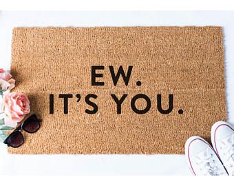 a door mat with the words ew it's you on it next to sunglasses and flowers