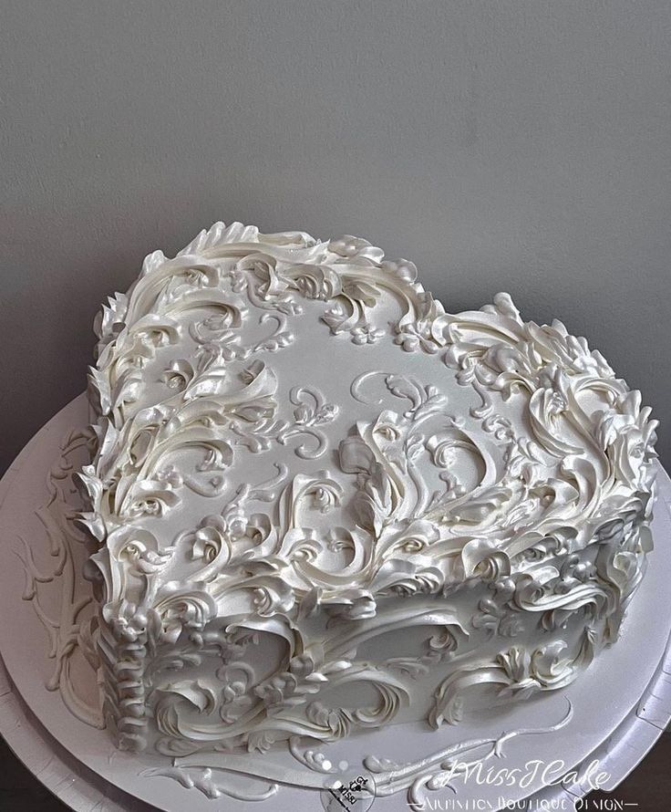 a large white cake sitting on top of a white platter covered in frosting