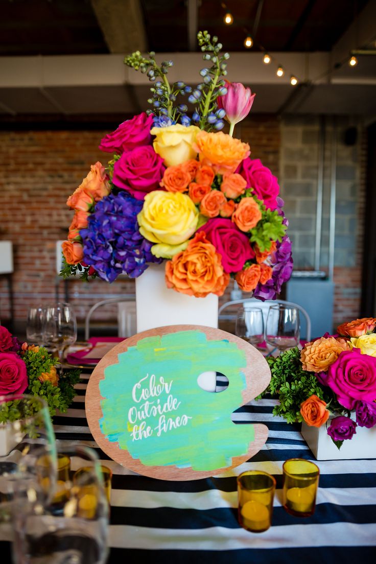 an arrangement of colorful flowers in vases on a table