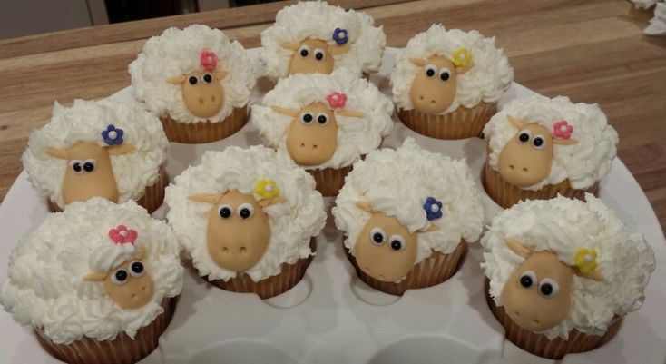 cupcakes decorated with sheep are sitting on a plate