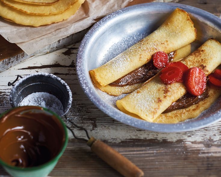 some food that is in a bowl on a table with chocolate and other things around it