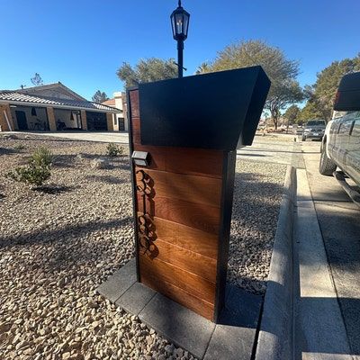 a wooden door sitting on the side of a road next to a street light and parked cars