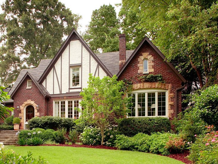 a house with lots of trees and bushes in the front yard, surrounded by greenery