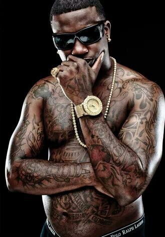 a man with tattoos on his chest wearing sunglasses and a gold chain around his neck