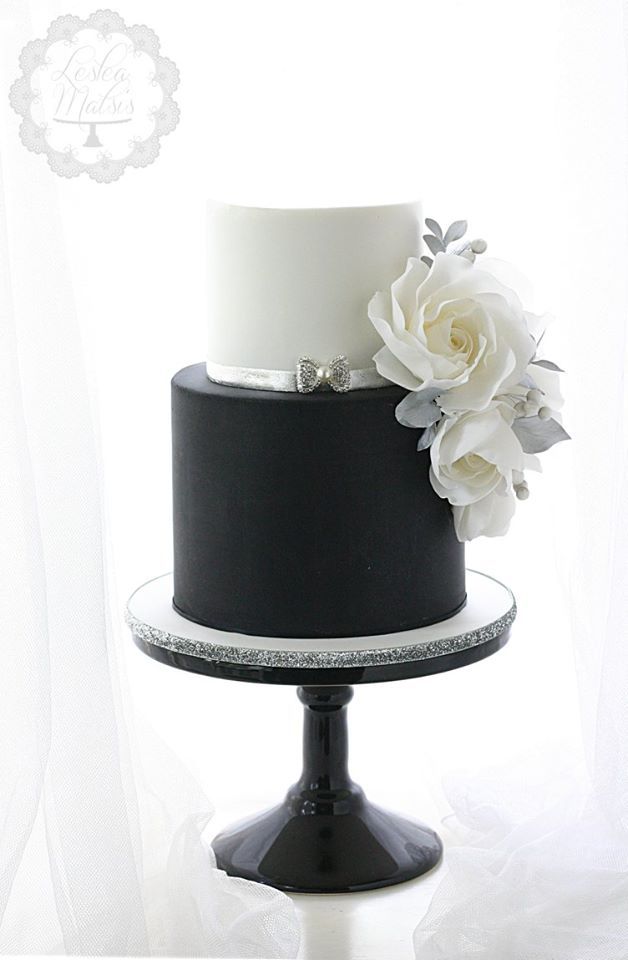 a black and white wedding cake with flowers on top