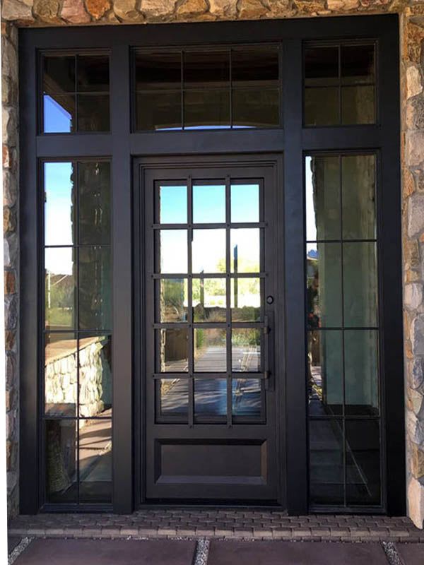 the front door to a home with double doors and glass panels on each side, surrounded by stone walls