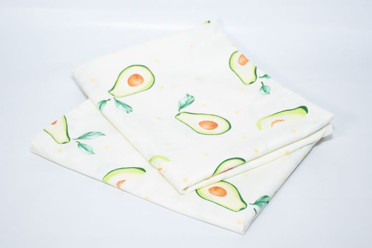 two avocado printed napkins sitting on top of each other