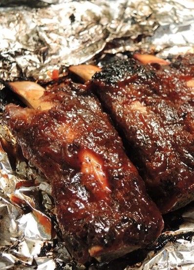 some meat is sitting on tin foil and ready to be grilled in the oven