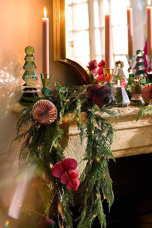 a mantle with candles and christmas decorations on it