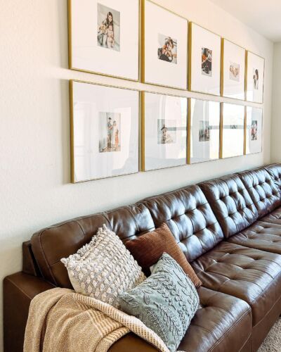 a living room filled with lots of furniture and pictures on the wall above it's couch