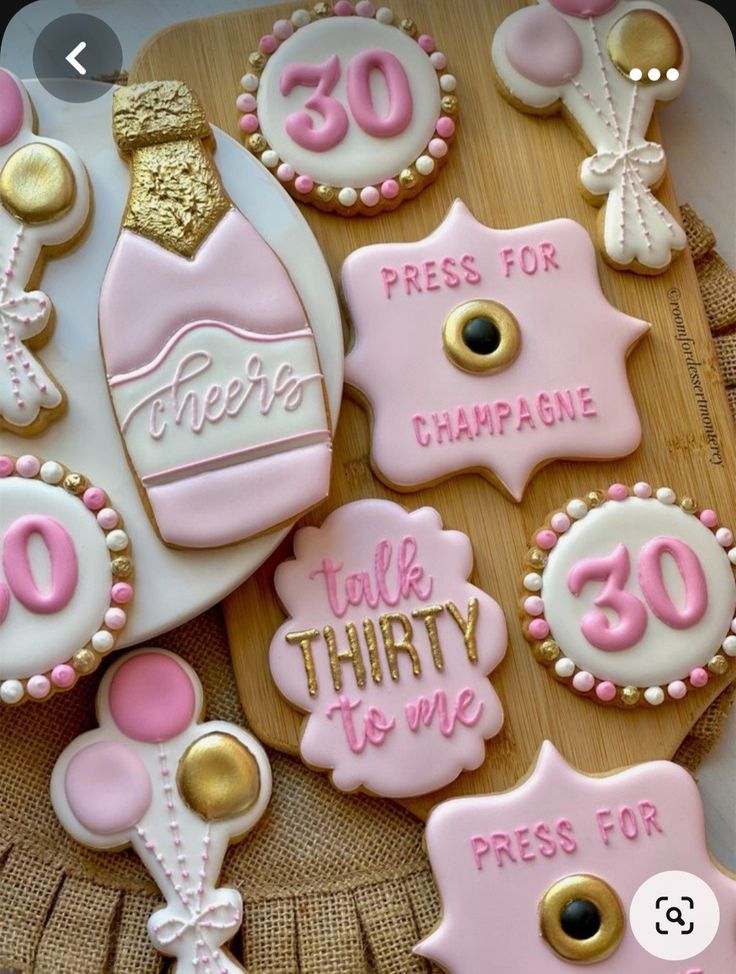 decorated cookies with pink and white icing are on a wooden platter that says, please for champagne talk thirty to me