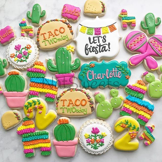 some decorated cookies are on a table with the words let's fiesta written on them