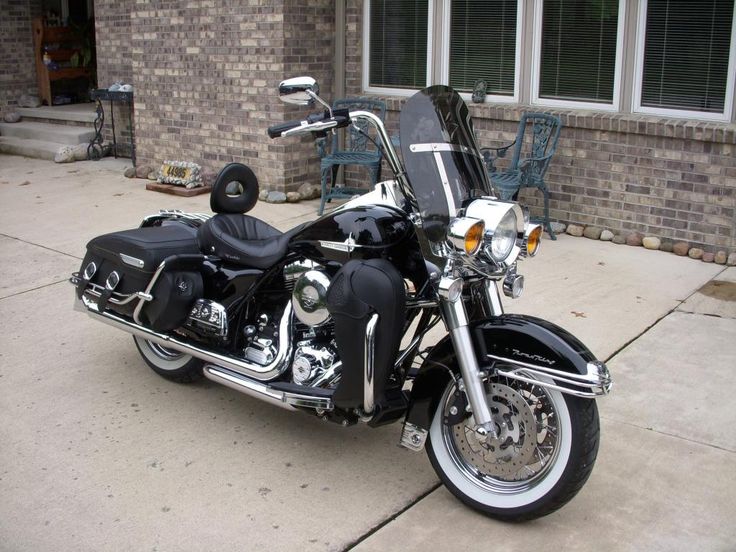 a black motorcycle parked in front of a brick building