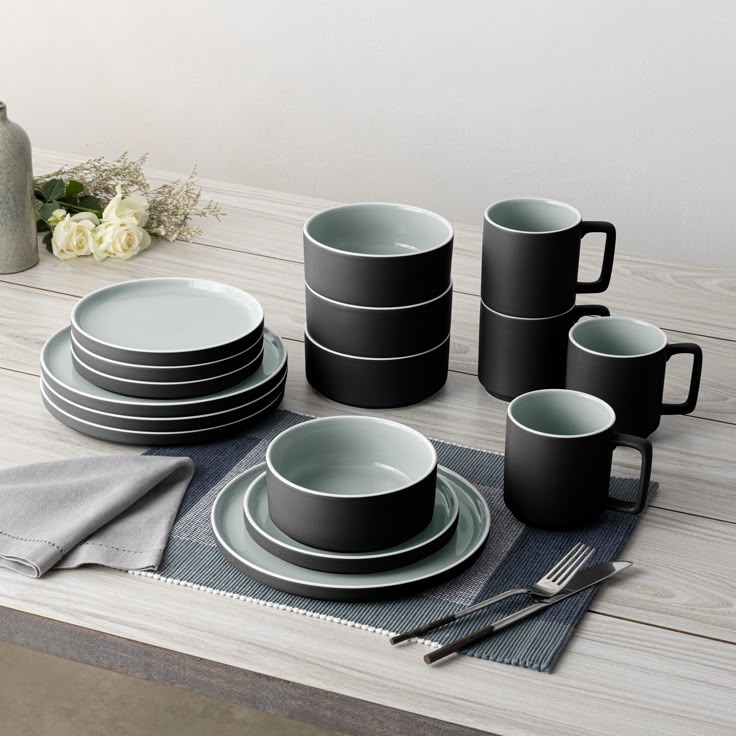 a table set with plates, cups and utensils